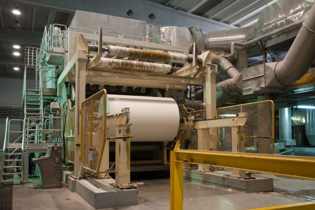 Pulp, Paper & Packaging Large paper roll moving through a paper mill production line